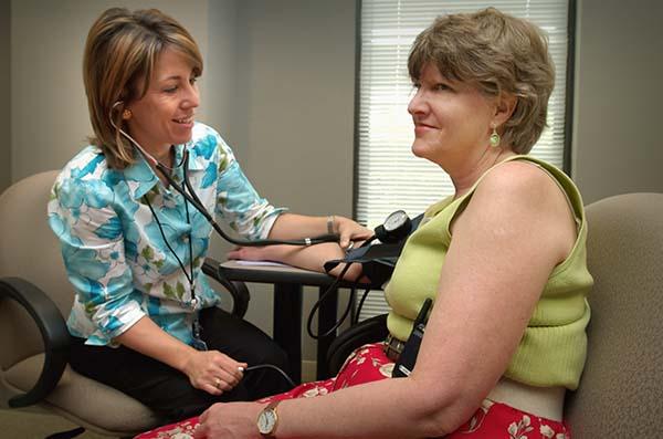 Doctor taking patient's blood pressure